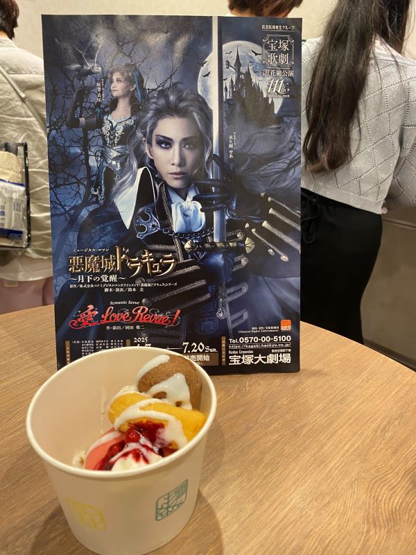 Disappointing ice cream donuts in front of a cardboard cutout of the Castlevania revue poster